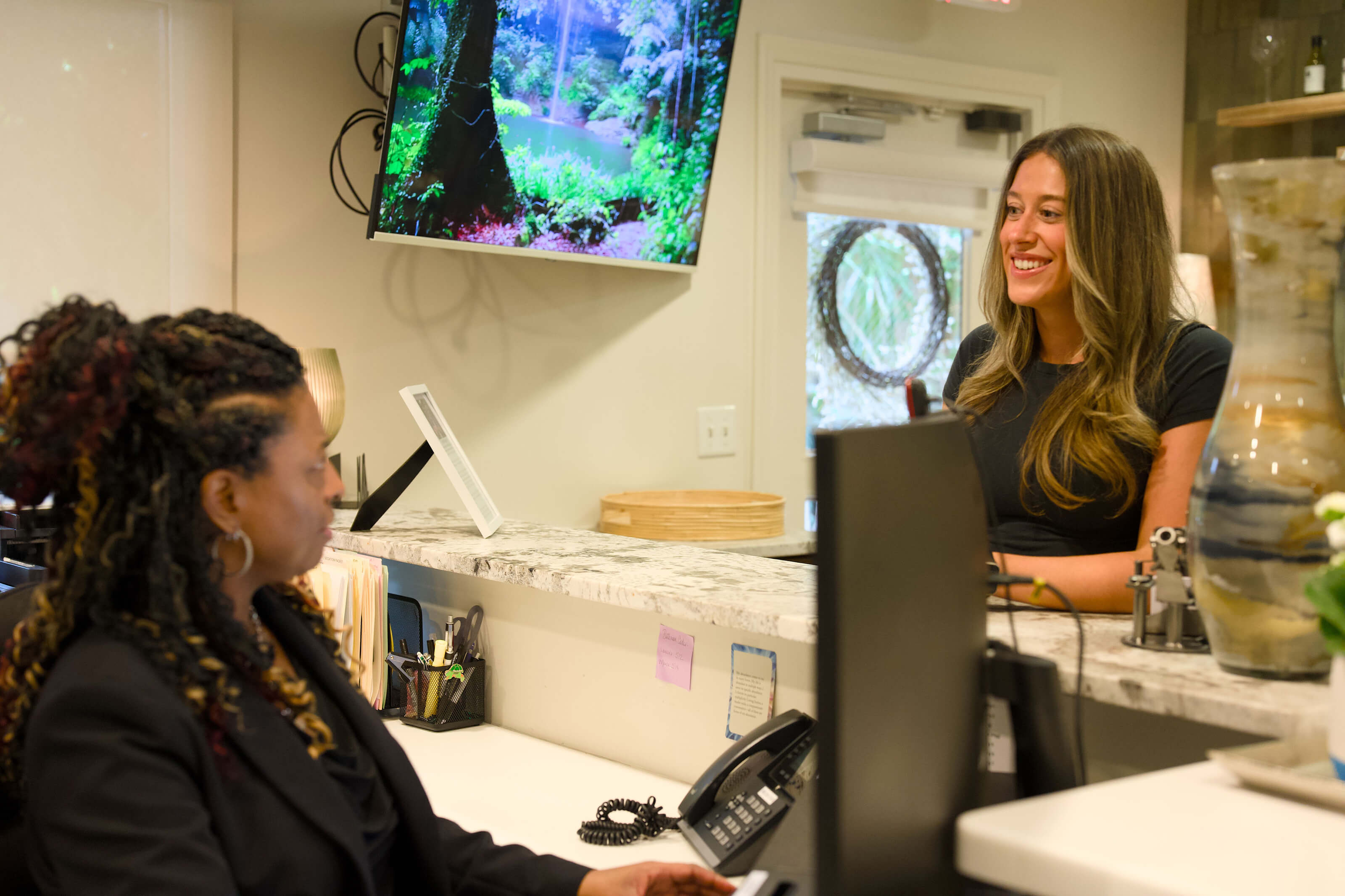 A Barrero Dental Boutique team member warmly checking in a patient
