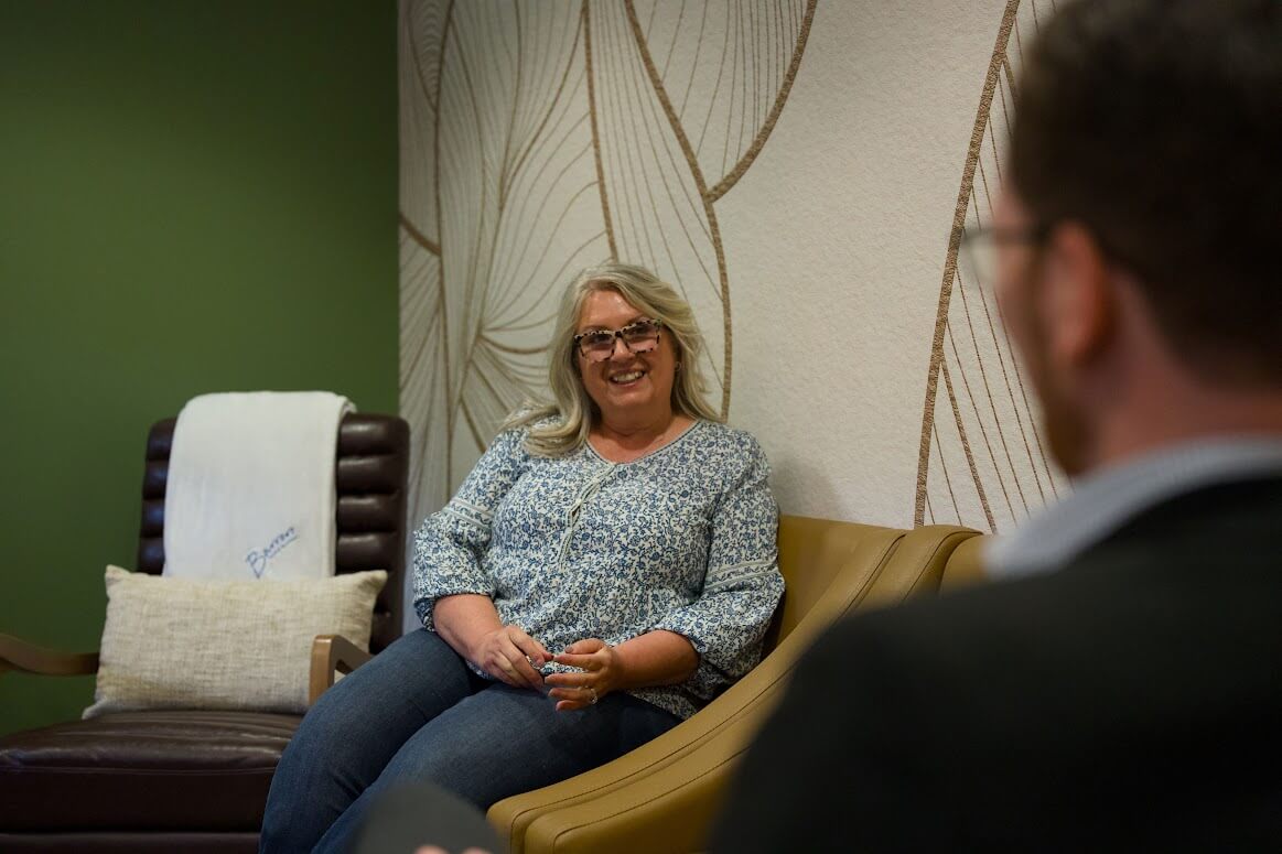 A patient having a relaxed conversation in the Barrero Dental Boutique waiting room
